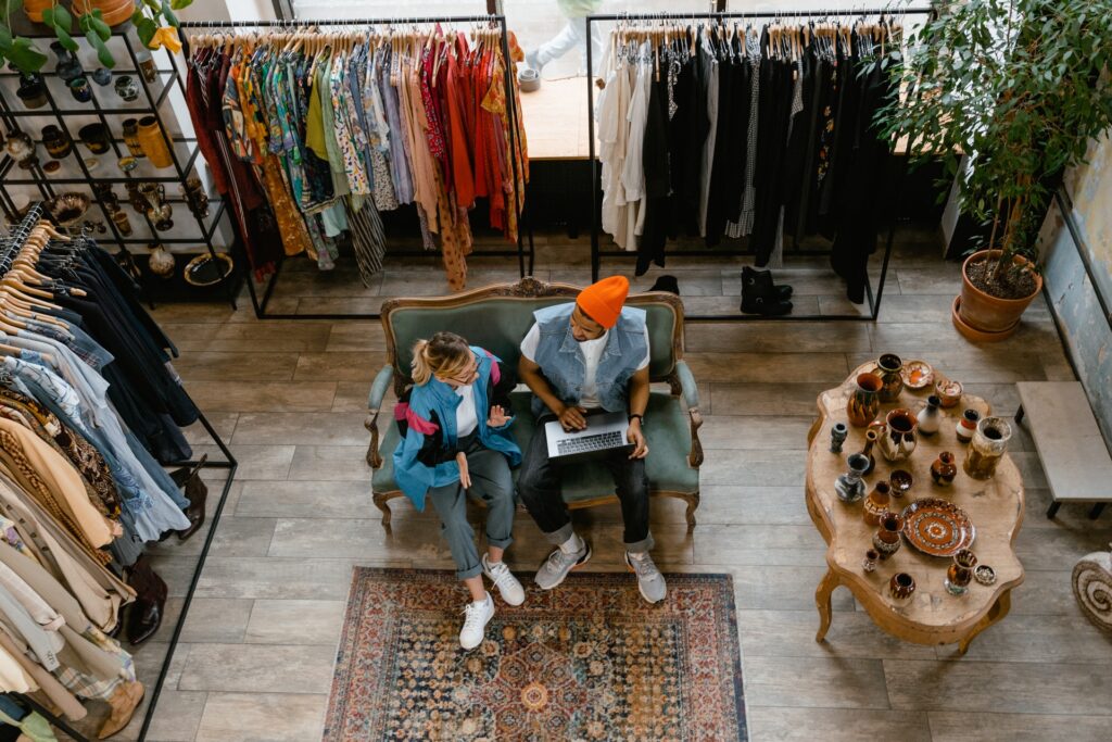 Emprendedores de tienda de ropa, organizando inventario grande en tienda en línea con Shopify.