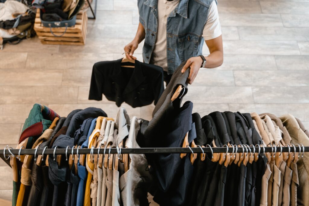 Hombre organizando tienda de ropa para crear colecciones en tienda en línea de Shopify.